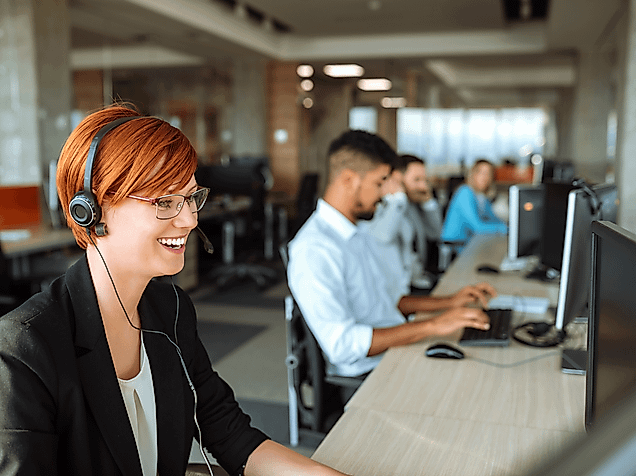 Lachende Frau am PC mit Headset im Hamburg Tourismus Call Center 